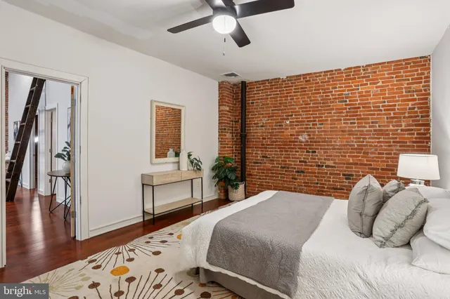 a bedroom with bed and paintings on the wall
