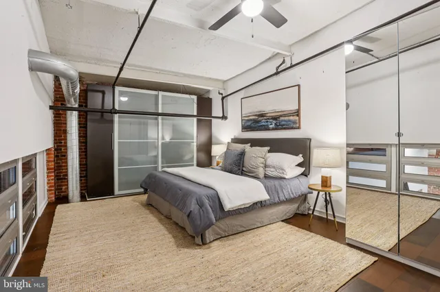 a bedroom with a large bed and a chandelier