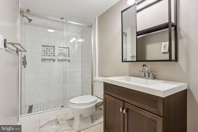 a bathroom with a sink a toilet and shower