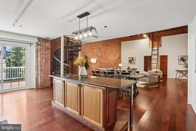 a kitchen with stainless steel appliances a dining table chairs and wooden floor