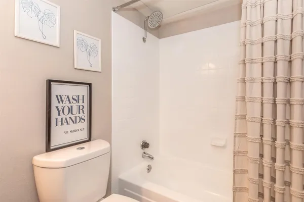 a white toilet sitting next to a shower curtain