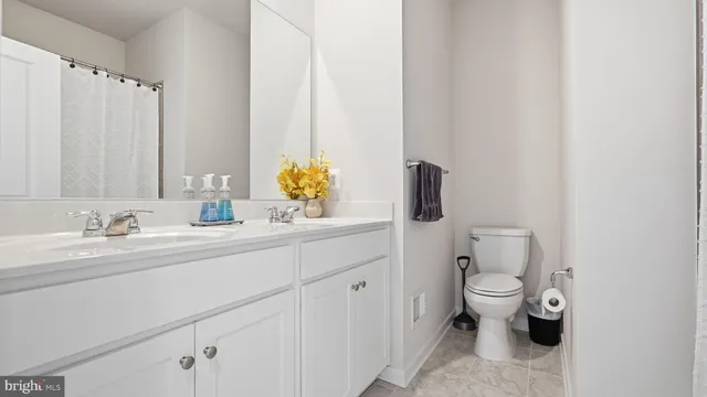 a bathroom with a granite countertop sink and a toilet
