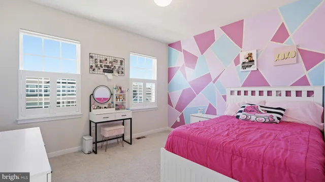 a bed room with a bed and a chair with paintings on wall