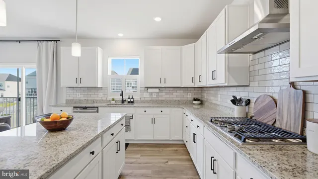 a kitchen with stainless steel appliances granite countertop a stove sink and cabinets