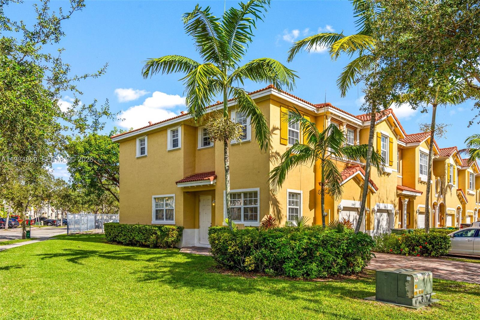 2109 Northeast 3rd Court Homestead, FL 33033 - Photo 2 of 19 a view of a white house with a big yard and potted plants and trees