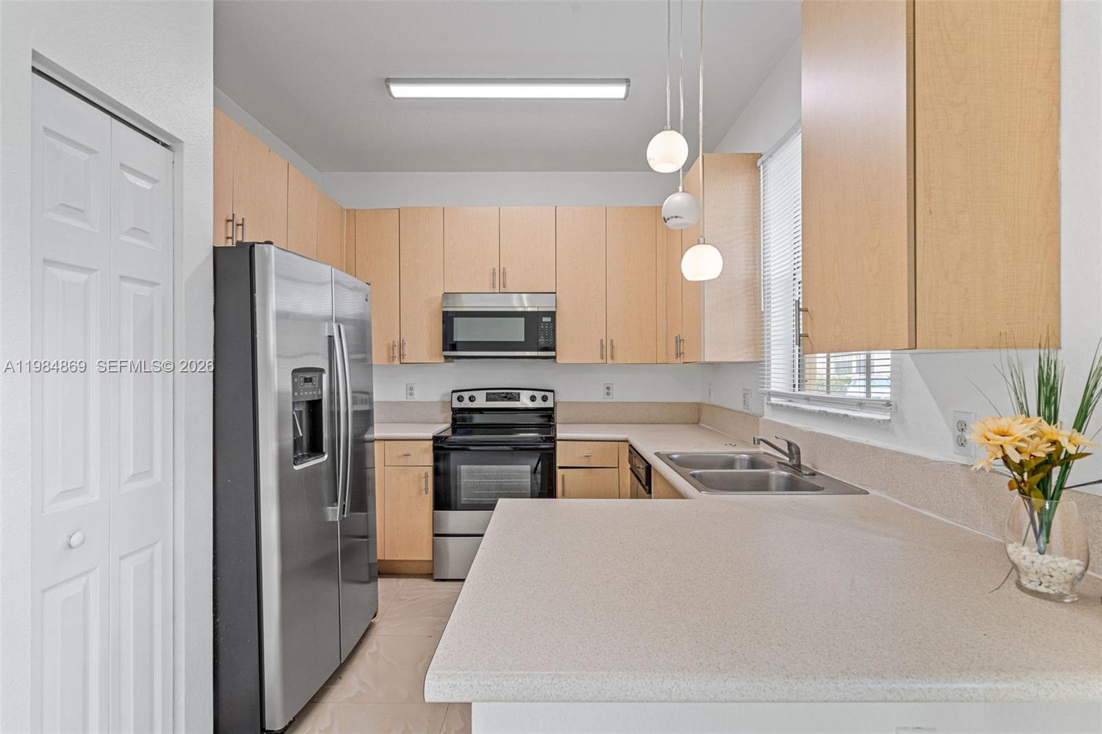 2109 Northeast 3rd Court Homestead, FL 33033 - Photo 8 of 19 a kitchen with white cabinets and stainless steel appliances