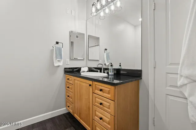 a bathroom with a granite countertop sink a mirror and vanity