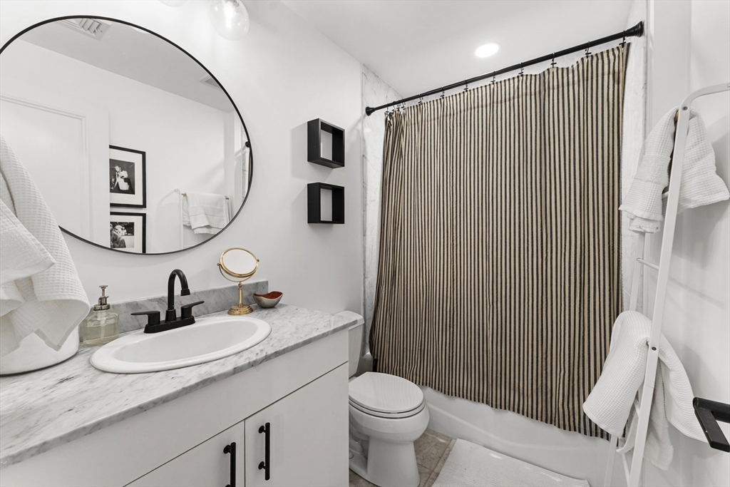 121 Beach Boston Ma, Unit 502 Boston, MA 02111 - Photo 11 of 21 a bathroom with a granite countertop sink toilet and mirror
