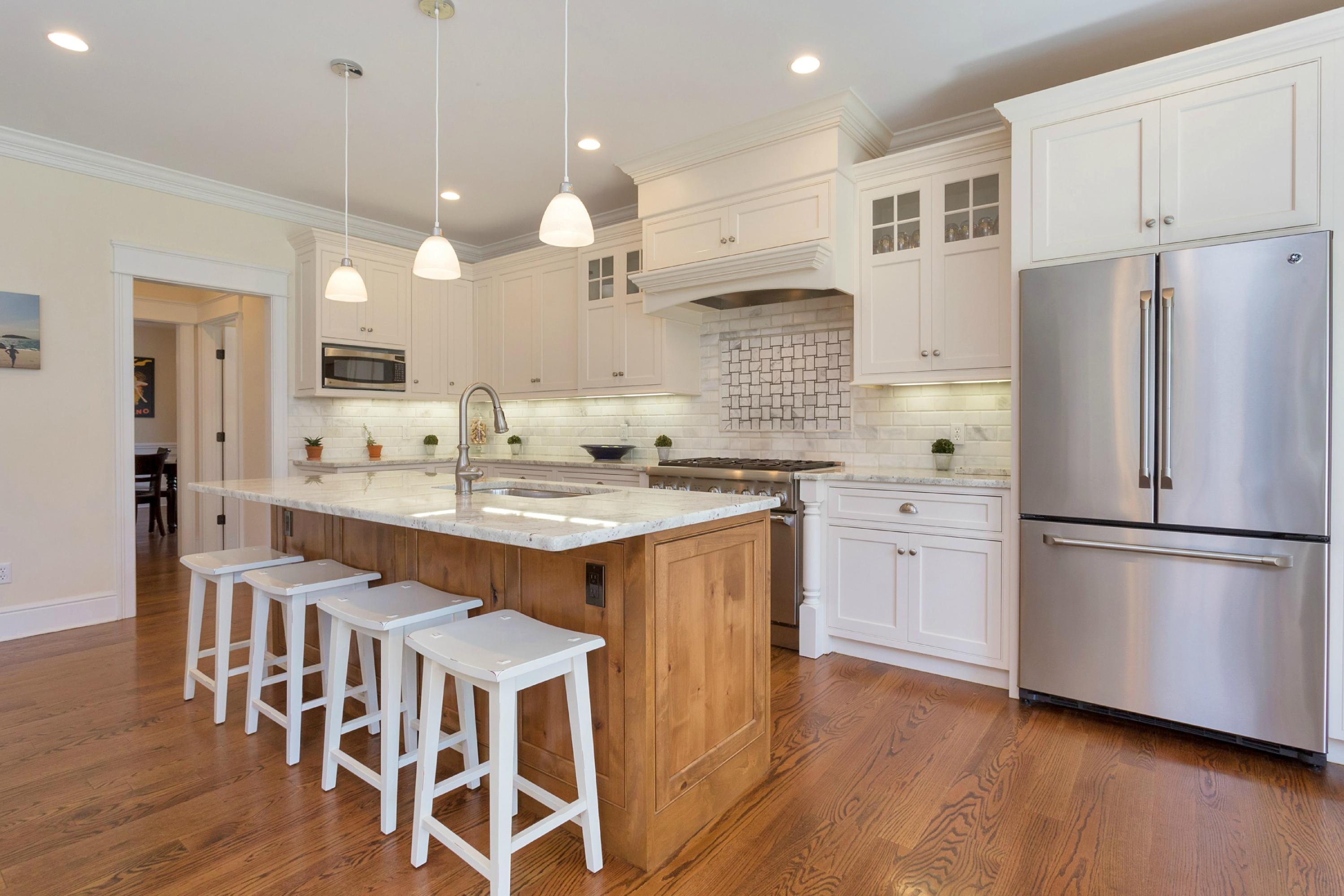 31 Edgewood Road Darien, CT 06820 - Photo 6 of 25 a kitchen with stainless steel appliances kitchen island granite countertop a refrigerator a stove a sink dishwasher and a dining table with wooden floor