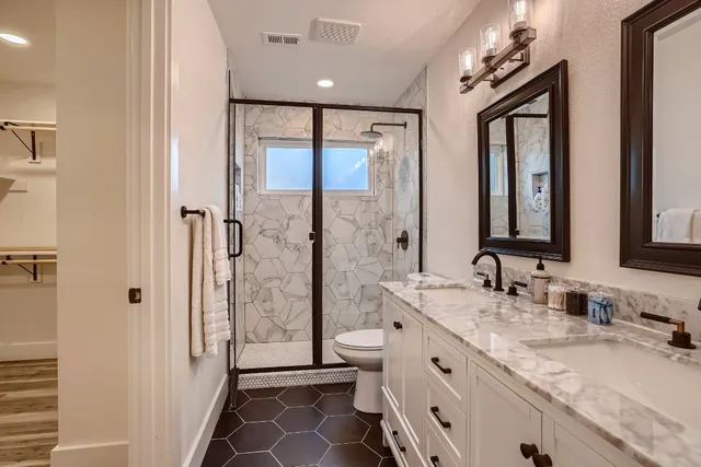 a spacious bathroom with double vanity and a mirror