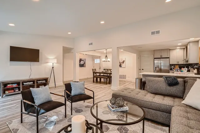 a living room with furniture kitchen view and a flat screen tv