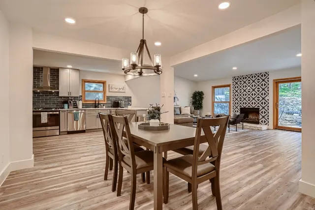 a view of a dining room and livingroom with furniture wooden floor a chandelier