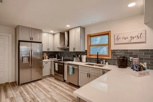 a kitchen with stainless steel appliances a refrigerator a sink a stove and cabinets