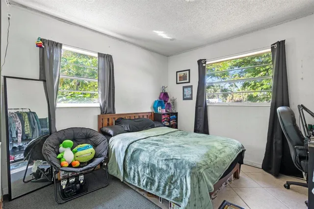 a bedroom with a bed a chandelier and a window