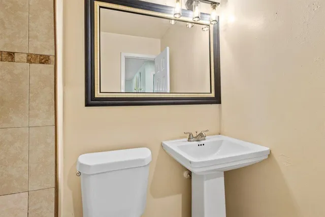 a bathroom with a sink a toilet and mirror