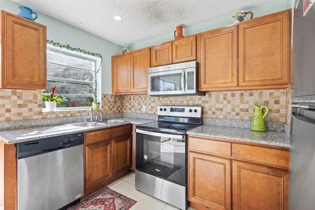 a kitchen with stainless steel appliances granite countertop a sink stove and cabinets