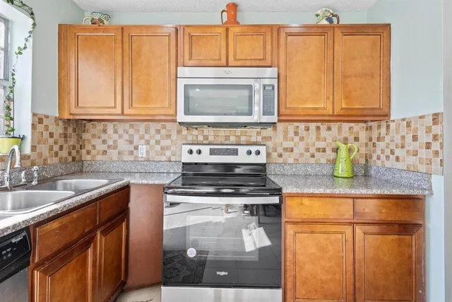 a kitchen with stainless steel appliances granite countertop a sink stove and cabinets