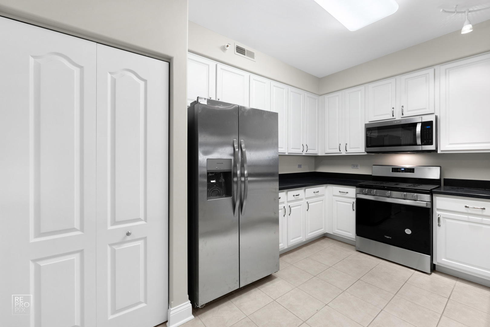 1 Itasca Place, Unit 207 Addison, IL 60143 - Photo 6 of 24 a modern kitchen with stainless steel appliances granite countertop a refrigerator and a stove top oven