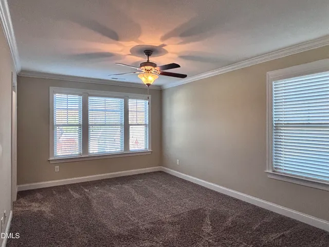 an empty room with a ceiling fan and window