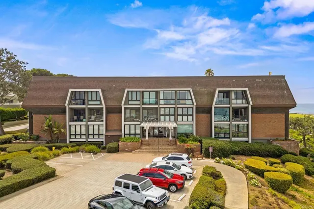 a view of a brick house with a swimming pool and furniture