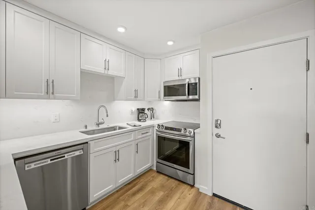 a kitchen with stainless steel appliances granite countertop a sink stove and refrigerator