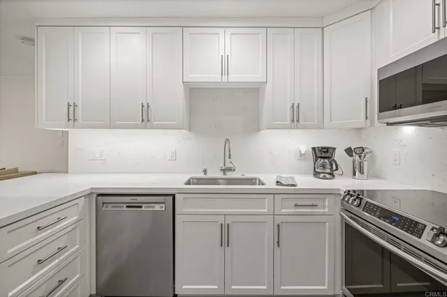 a kitchen with white cabinets and appliances
