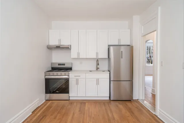 a kitchen with a refrigerator sink and cabinets