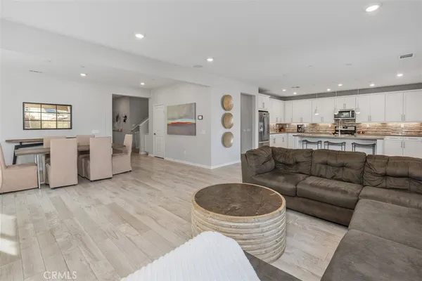 a living room with furniture and a view of kitchen