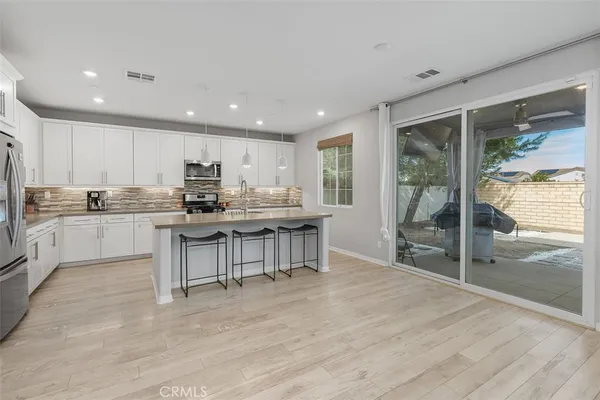 a kitchen with stainless steel appliances granite countertop a stove top oven a sink refrigerator and cabinets