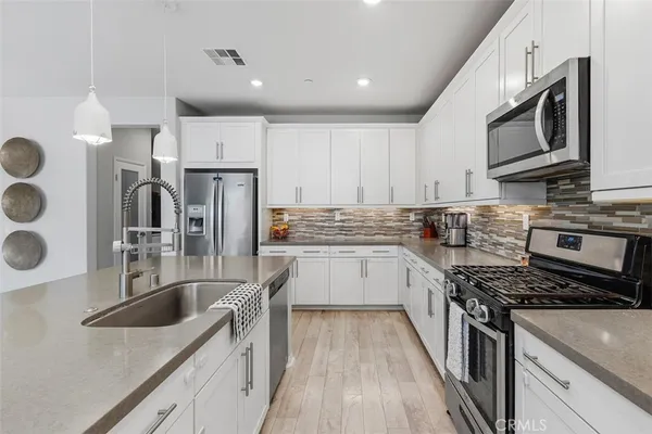 a kitchen with stainless steel appliances granite countertop a sink stove and refrigerator