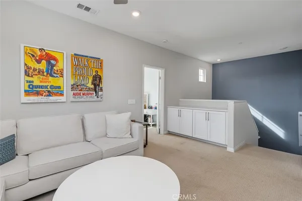 a living room with furniture and a painting on the wall
