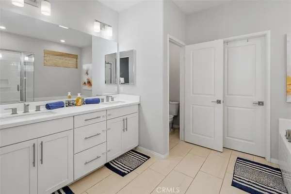 a spacious bathroom with a double vanity sink a mirror and a shower