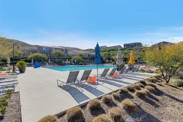 a view of swimming pool with a table and chairs under an umbrella