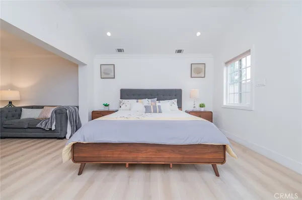 a bedroom with a bed and wooden floor