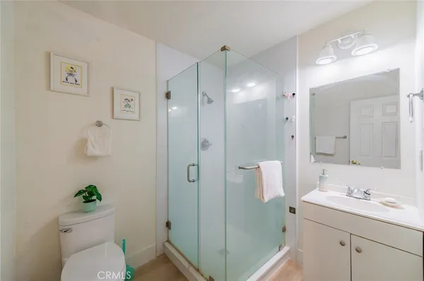 a bathroom with a granite countertop sink a toilet and shower
