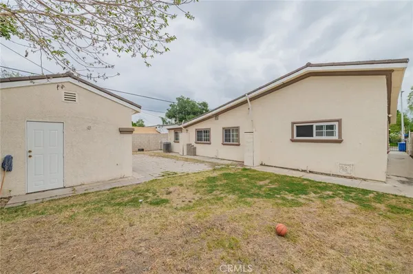 a view of a house with backyard and wooden fence