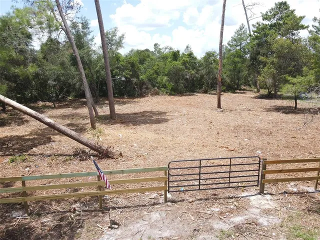 a view of a yard with wooden fence and a bench