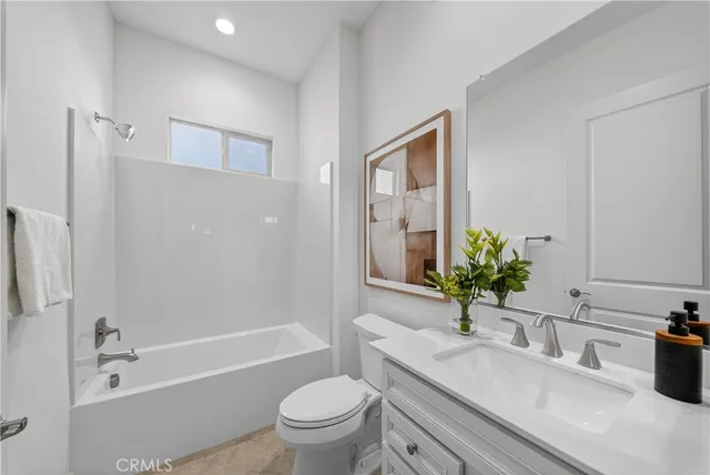 a bathroom with a granite countertop sink a toilet a mirror a vanity and shower