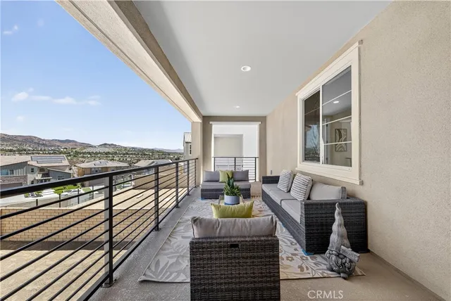 a balcony with furniture and large windows