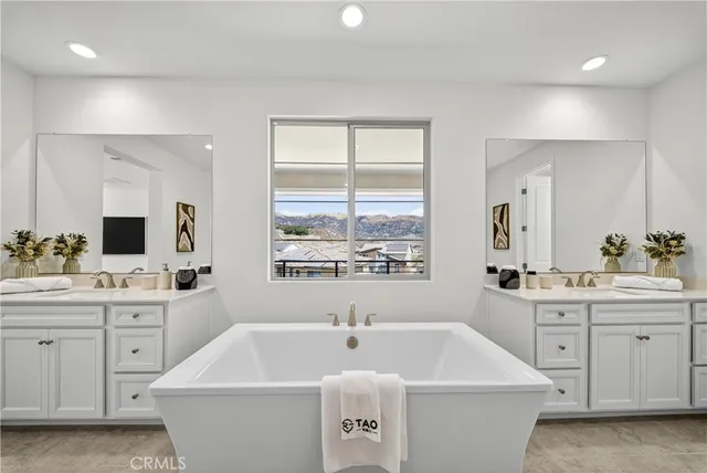 a bathroom with a sink a large mirror and a bathtub