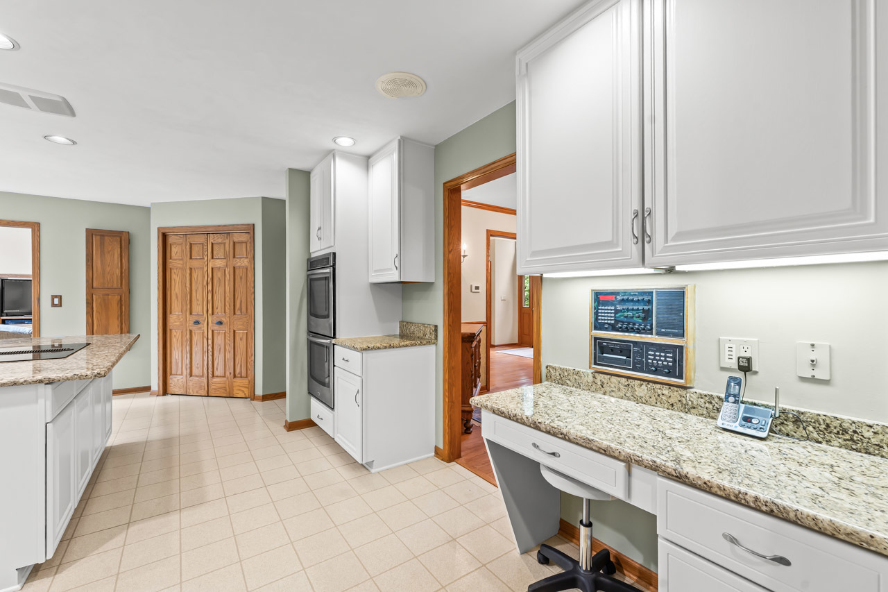 31W139 Rohrssen Road Hoffman Estates, IL 60192 - Photo 25 of 51 a kitchen with granite countertop a sink and white cabinets