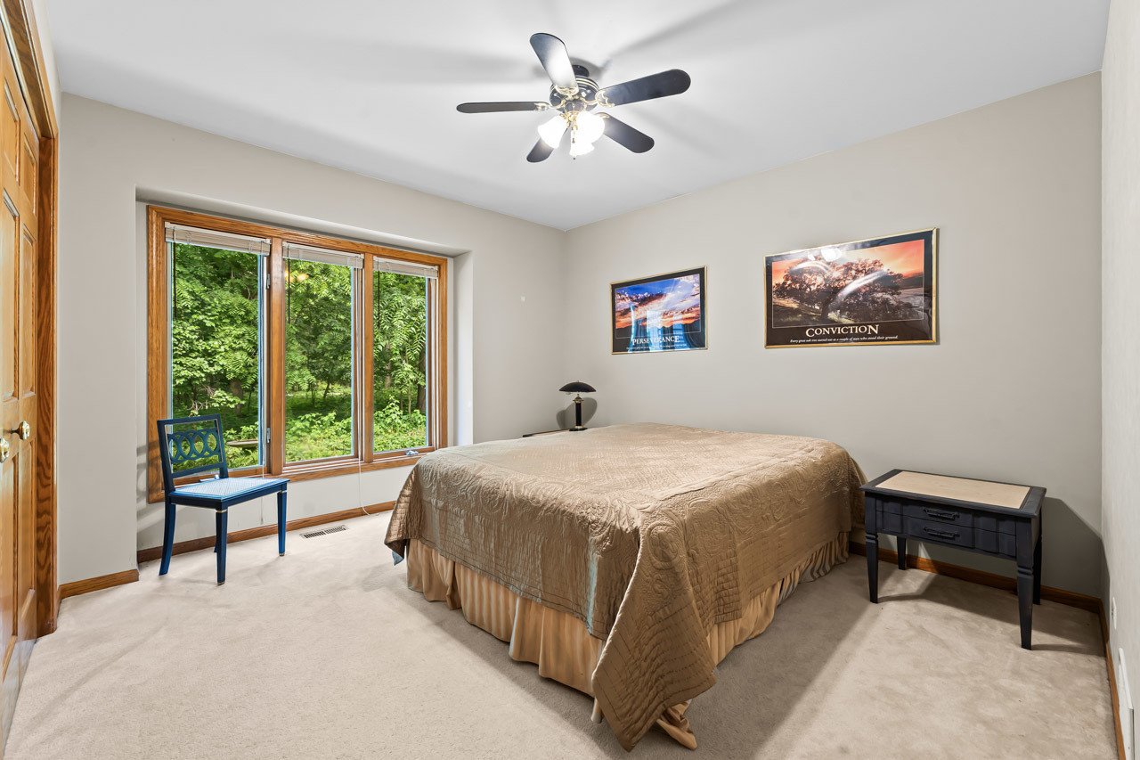 31W139 Rohrssen Road Hoffman Estates, IL 60192 - Photo 26 of 51 a bedroom with a bed and a chandelier