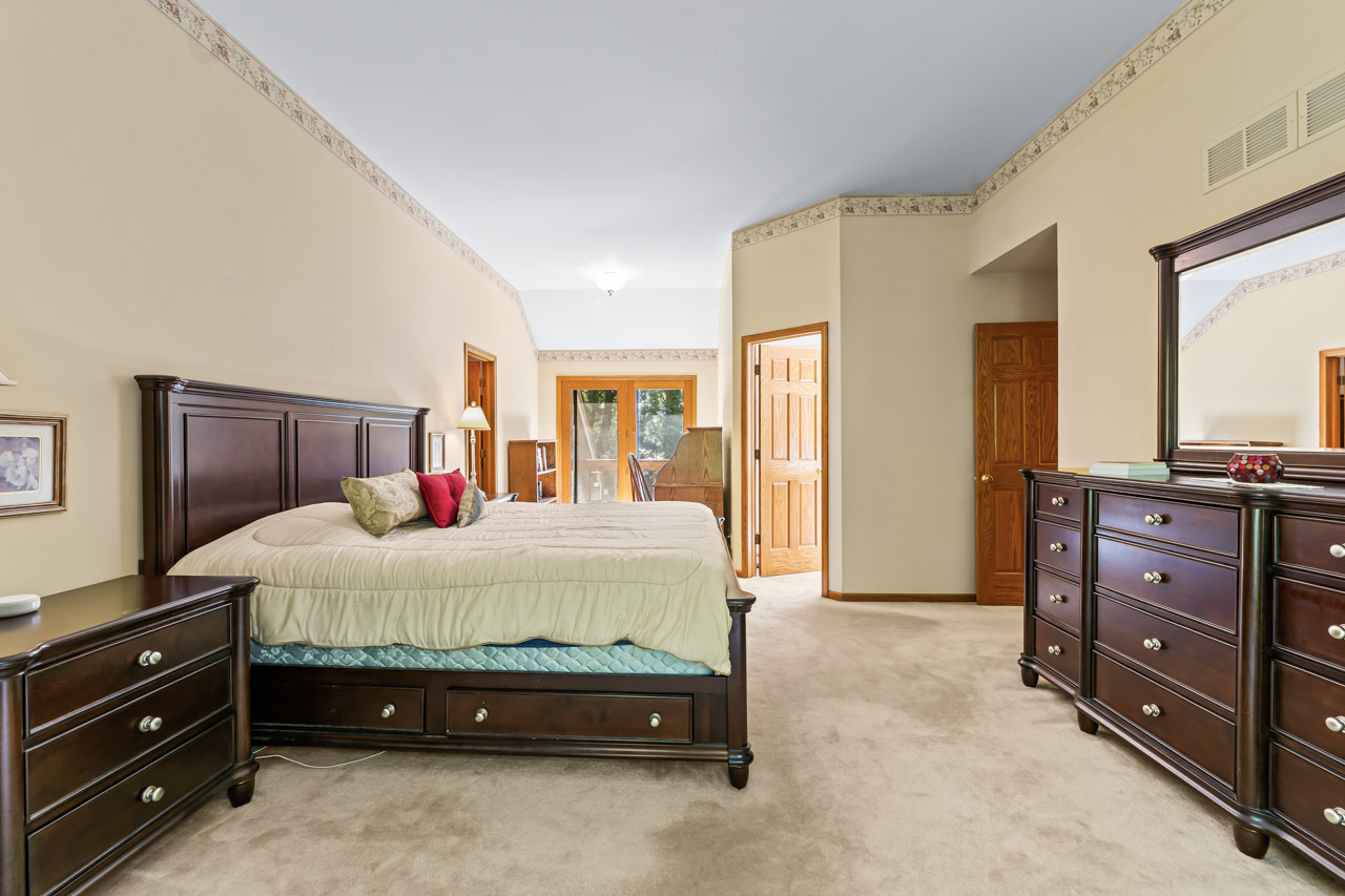 31W139 Rohrssen Road Hoffman Estates, IL 60192 - Photo 32 of 51 a spacious bedroom with a bed and a dresser