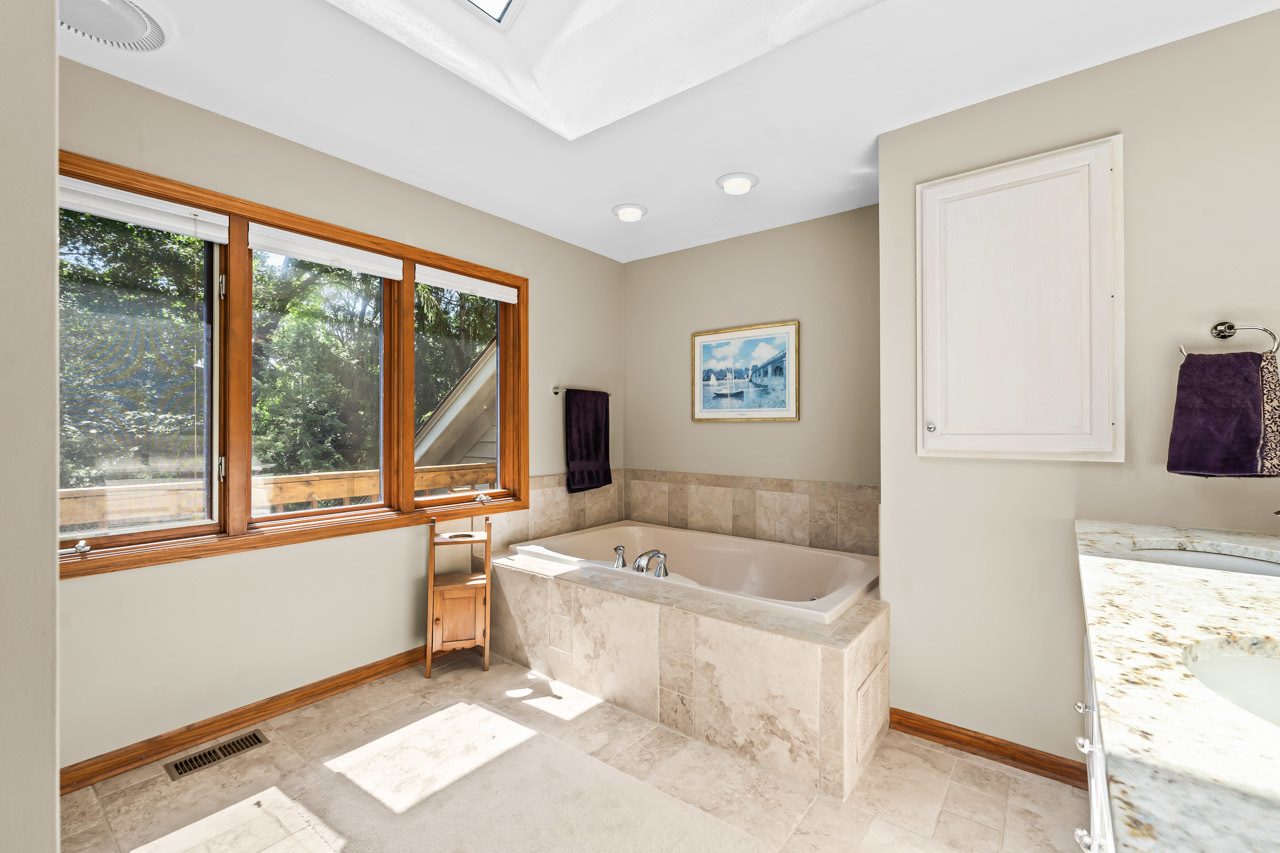 31W139 Rohrssen Road Hoffman Estates, IL 60192 - Photo 34 of 51 a bathroom with a tub a sink and a large window