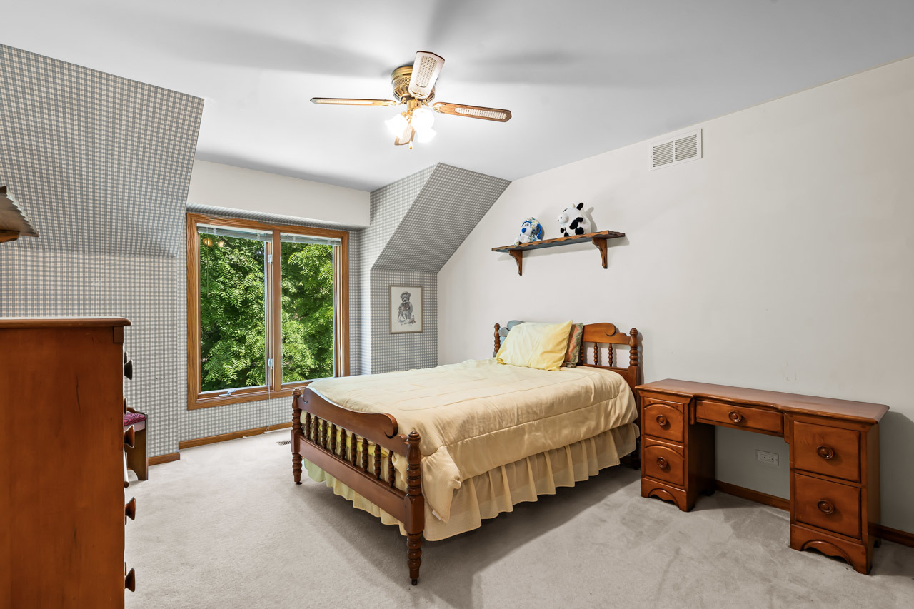 31W139 Rohrssen Road Hoffman Estates, IL 60192 - Photo 36 of 51 a bedroom with a bed and a chandelier