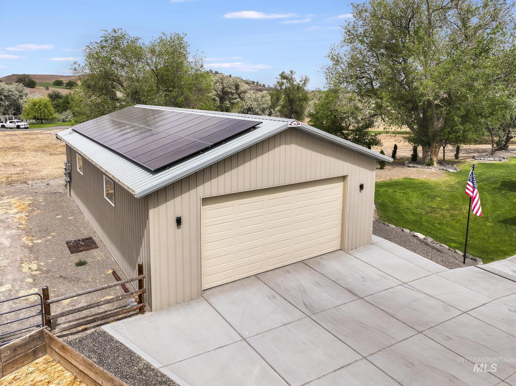 4485 Silver Creek Road Buhl, ID 83316 - Photo 4 of 49 Detached garage featuring solar panels, a metal roof, and a panel-style garage door
