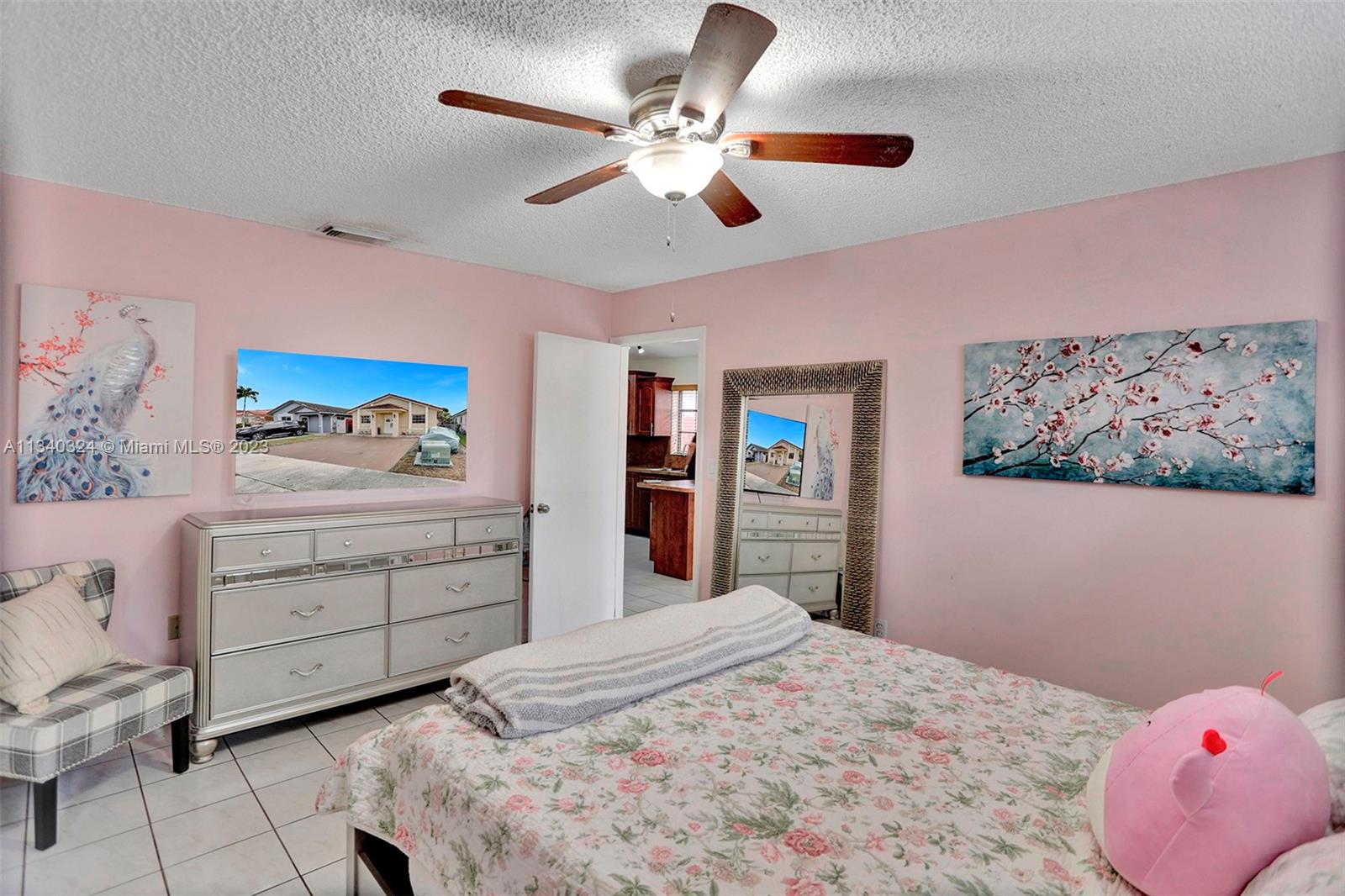 2574 West 71st Place Hialeah, FL 33016 - Photo 16 of 48 a bedroom with a bed and a chandelier