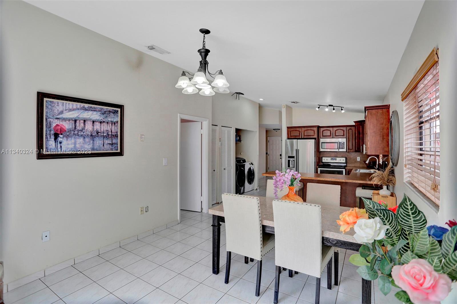 2574 West 71st Place Hialeah, FL 33016 - Photo 22 of 48 a view of a dining room with furniture and a chandelier