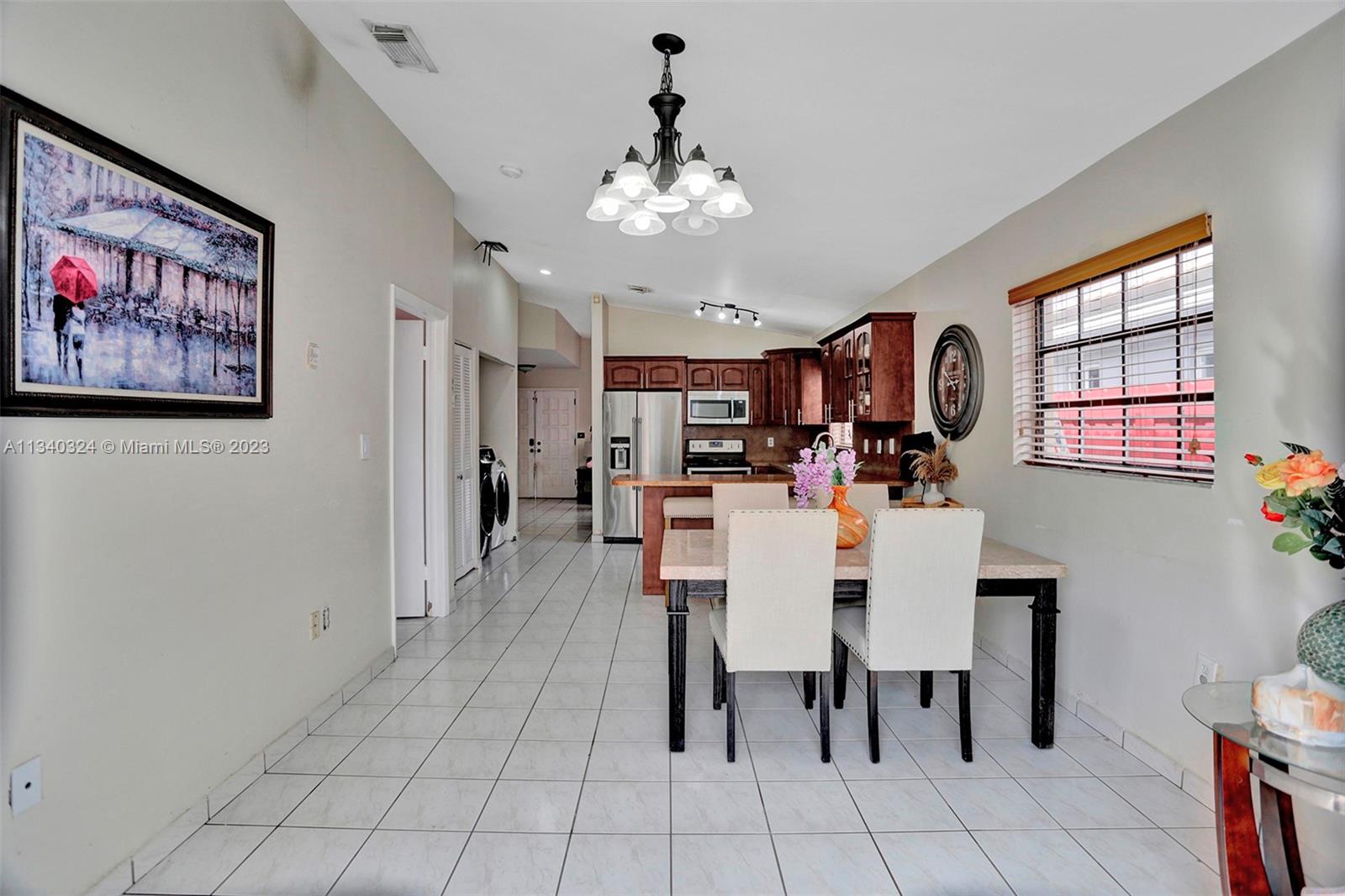 2574 West 71st Place Hialeah, FL 33016 - Photo 23 of 48 a view of a dining room with furniture and chandelier