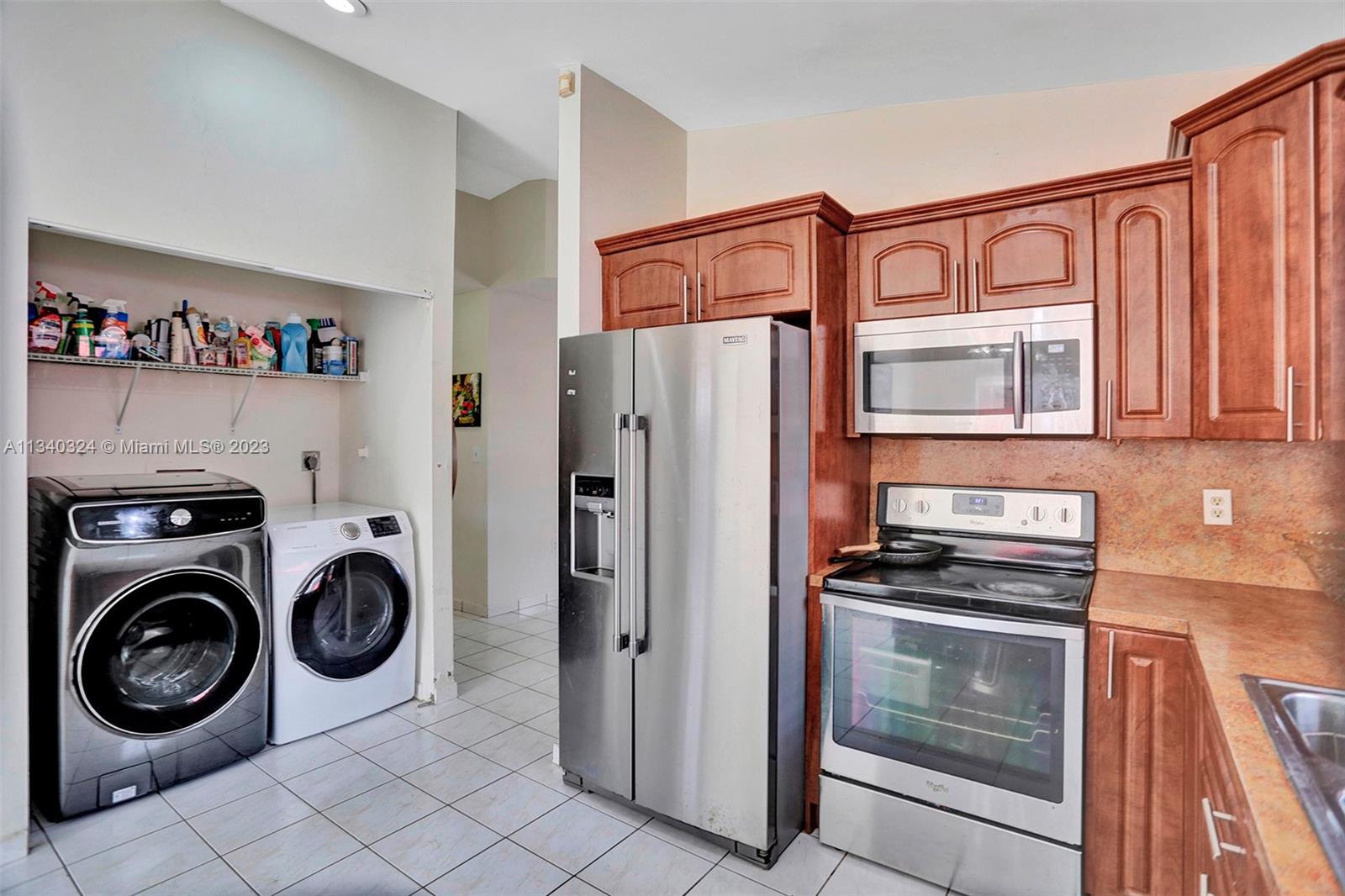 2574 West 71st Place Hialeah, FL 33016 - Photo 28 of 48 a view of a refrigerator and washer in a kitchen